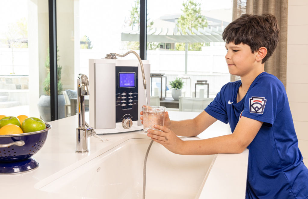 A countertop UltraWater alkaline ionizer in use at the kitchen sink